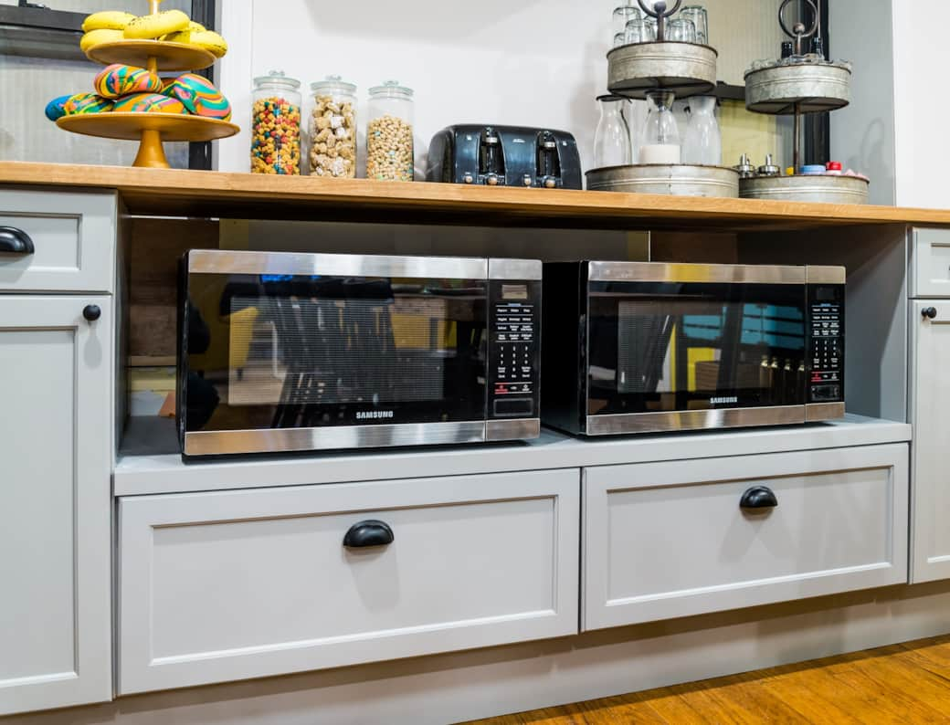 This kitchen setup showcases two microwaves, providing both style and functionality