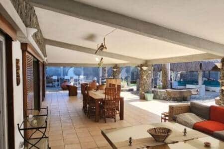 Grande veranda de 100 m2 avec 2 salons et une salle à manger. Acces direct à la cuisine.