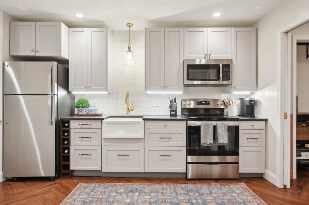 The fully-equipped kitchen includes a four-burner range, full fridge and freezer, and dishwasher.