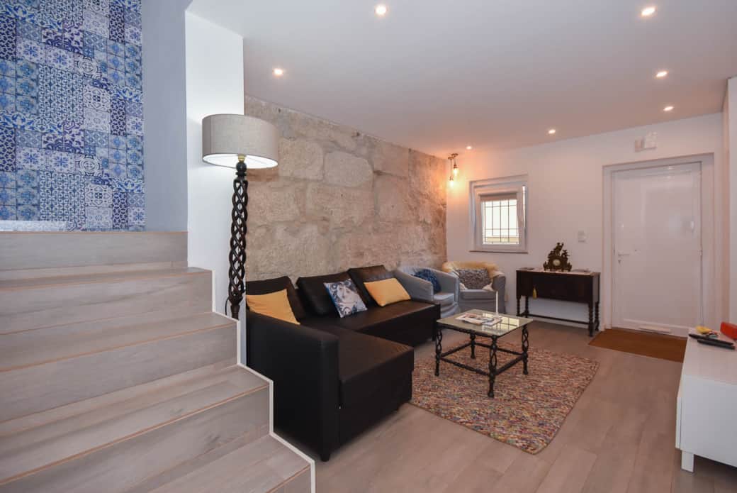 Relax in the cozy living area, where modern comforts meet an original stone wall.