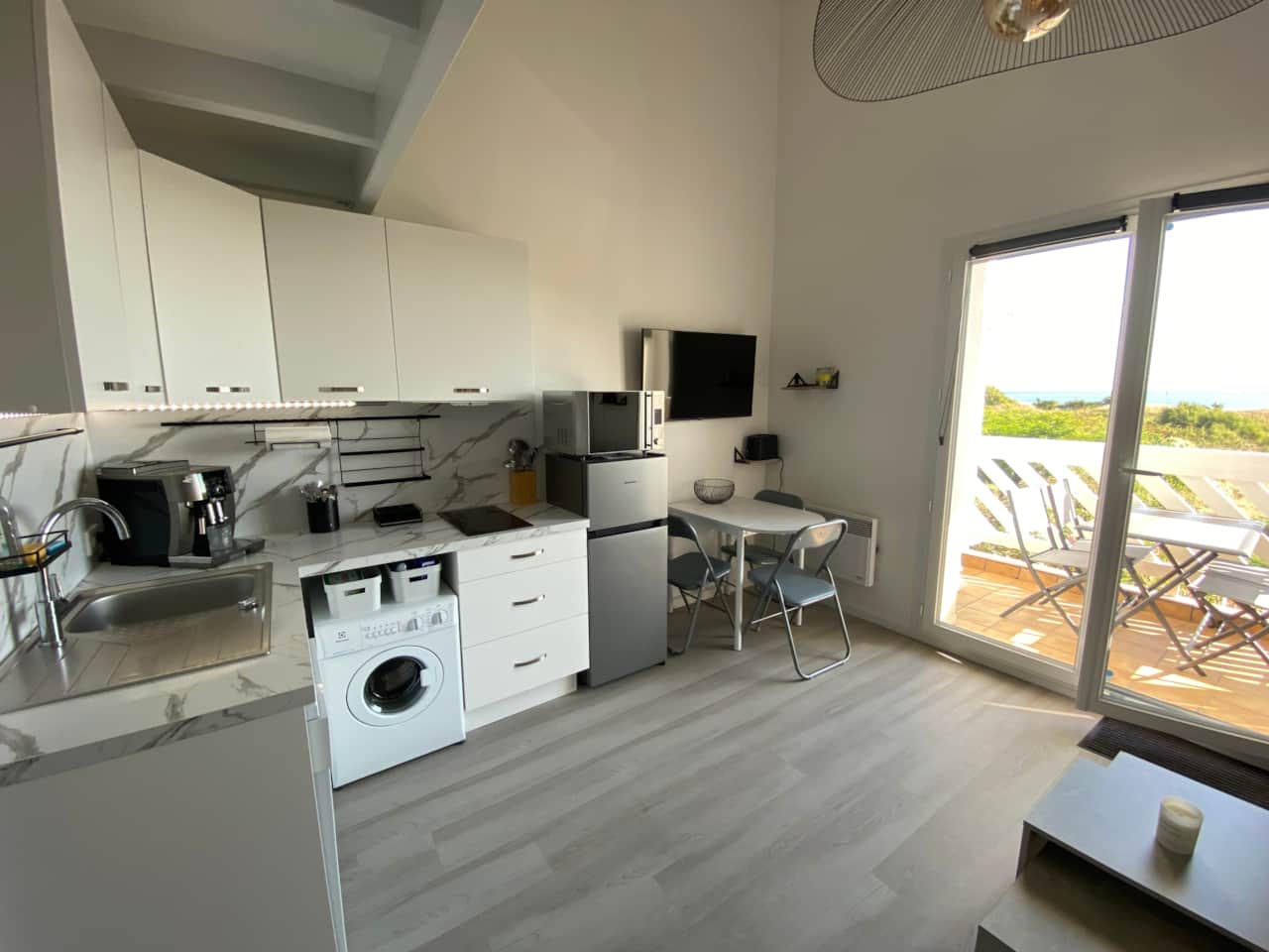 Bright living area with open kitchen and access to the balcony
