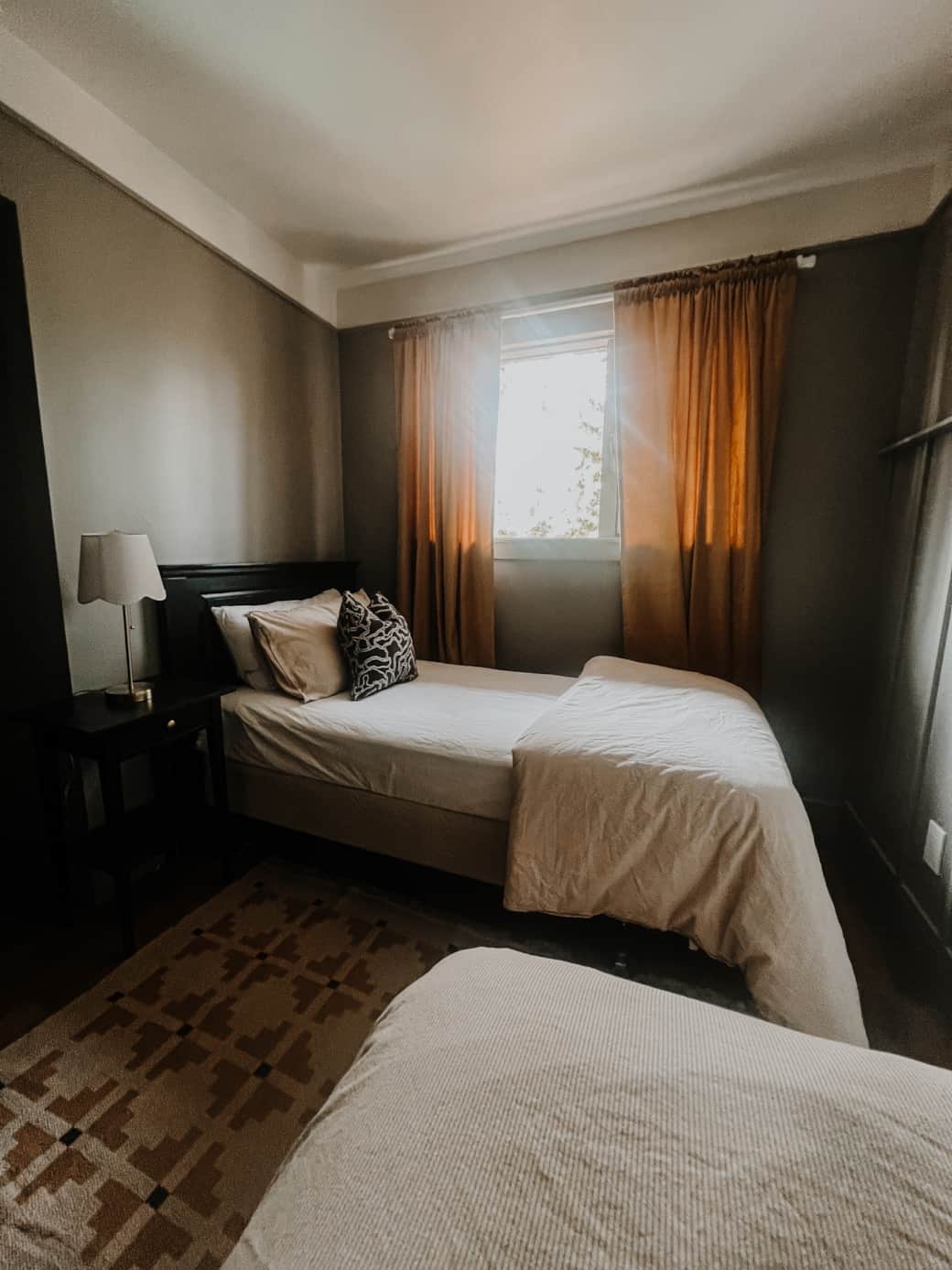 Sophisticated twin room with earthy tones and plenty of natural light.