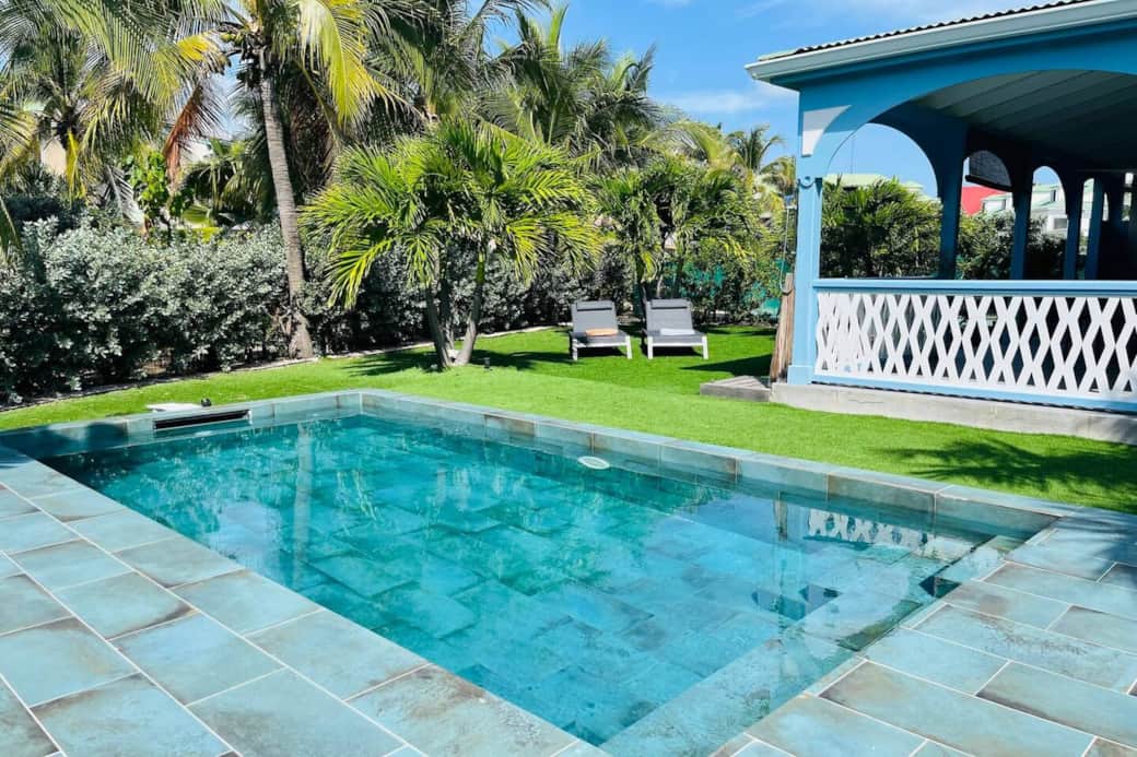 Pool with deck chairs and garden Silove