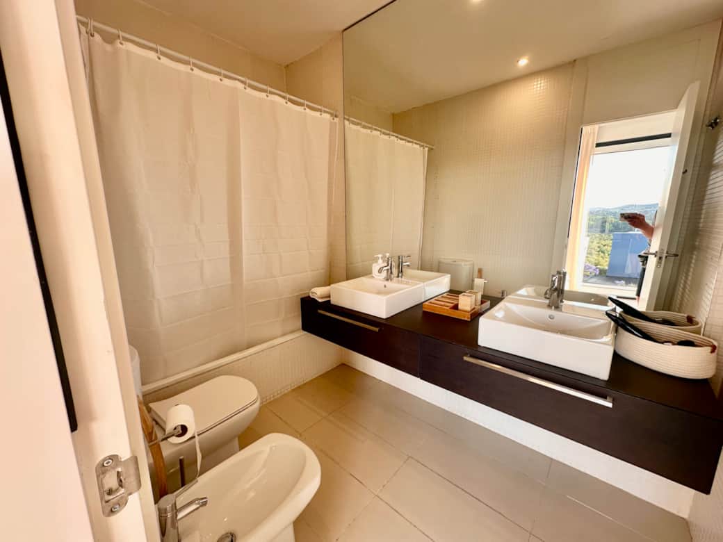 Ensuite 1 on the first floor with double sinks, bidet, WC and low level bath with shower over