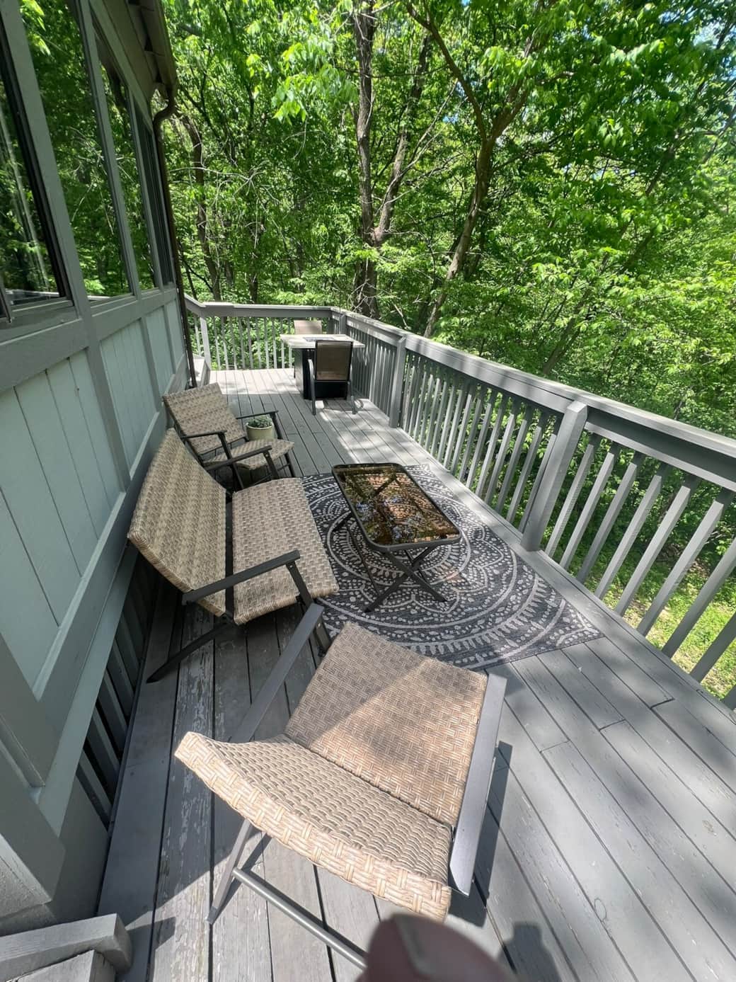 Back deck with extra seating, propane fire pit table, and Weber grill