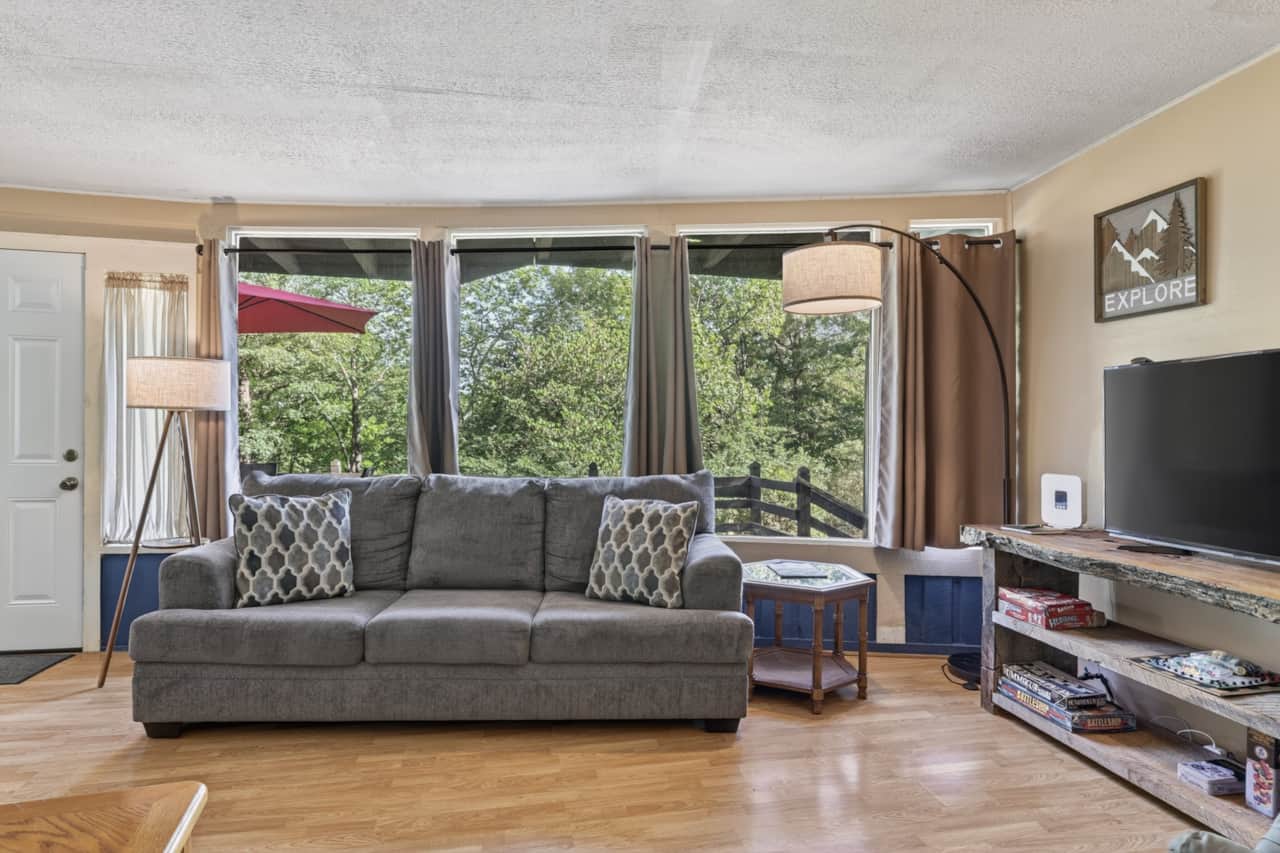 Cozy living room with a full wall of front windows to connect you with nature. 