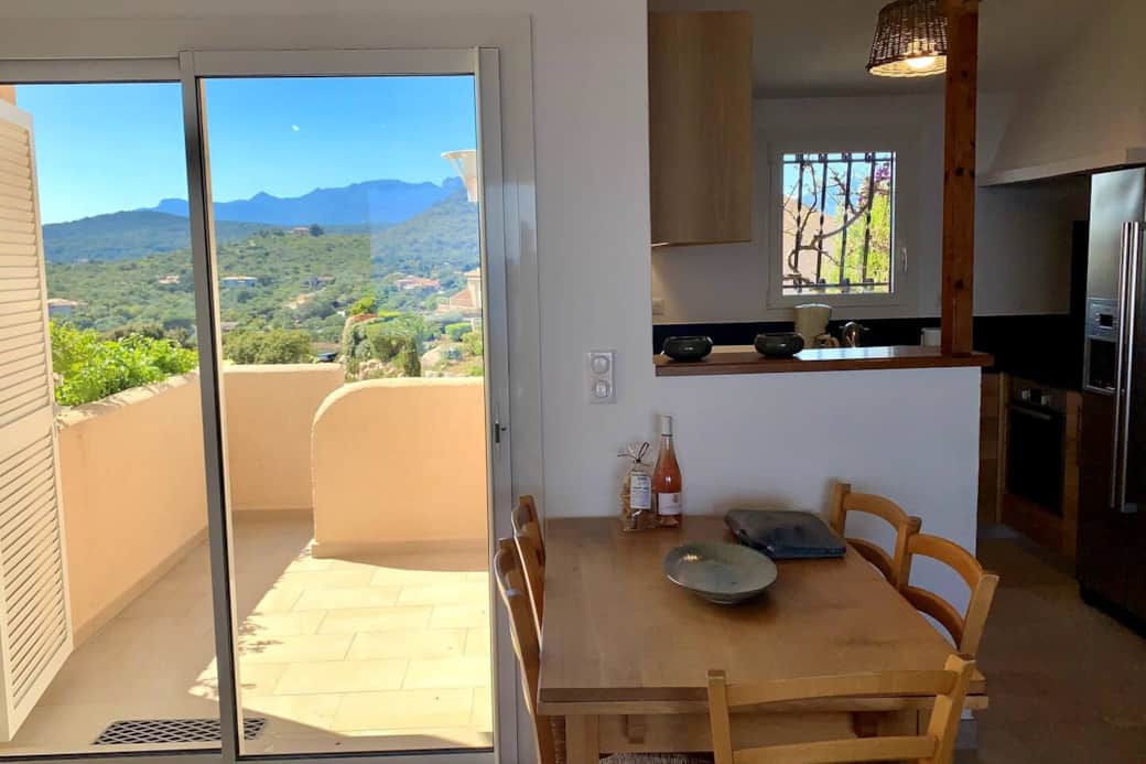 La terrasse côté montagnes, le coin repas et la cuisine.