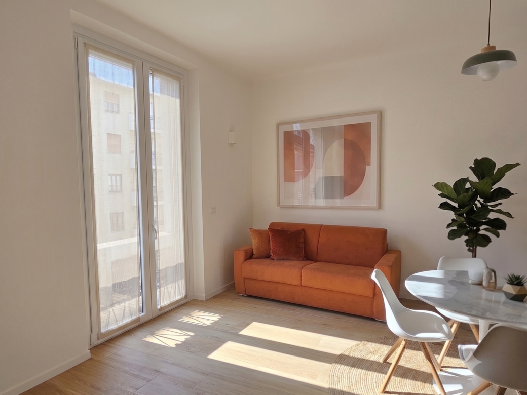 Wohnzimmer mit Sofa und Esstisch, Apartment Stay Navigli in Mailand.