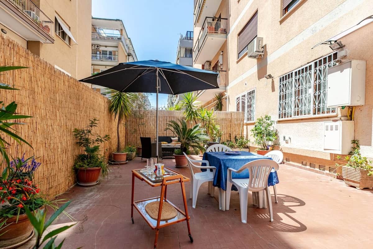 Terrazzo arredato con tavolo da pranzo e ombrellone.