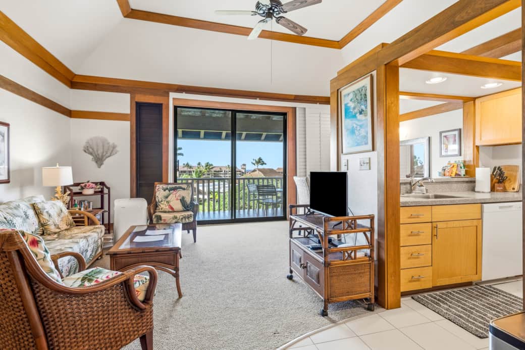 Spacious island condo with comfy seating, bright living area, and lanai overlooking greenery.