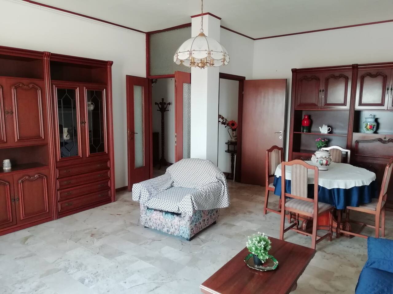 Panoramica del salotto con divano, poltrona e tavolo da pranzo