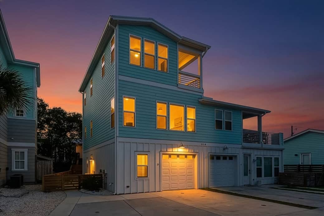 A glowing welcome!  Our 3-level Kure Beach retreat shines at sunset. With rare parking for 4 vehicles and a prime location, your coastal getaway starts the moment you pull into the driveway. Modern, spacious, and ready for your group!