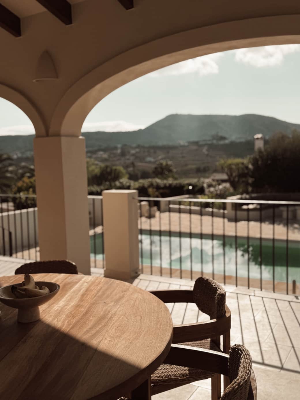 Buitentafel voor 6 personen met uitzicht op zwembad en vallei.