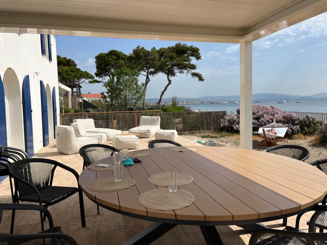 Grande terrasse avec une table pour 12 personnes sous la pergola