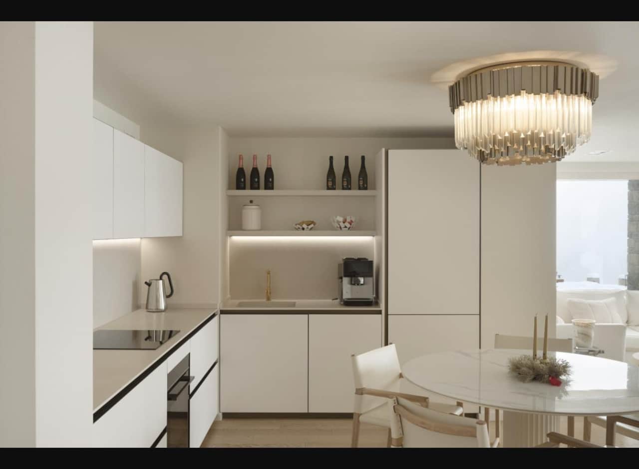 Fully equipped kitchen with dining table under a crystal chandelier
