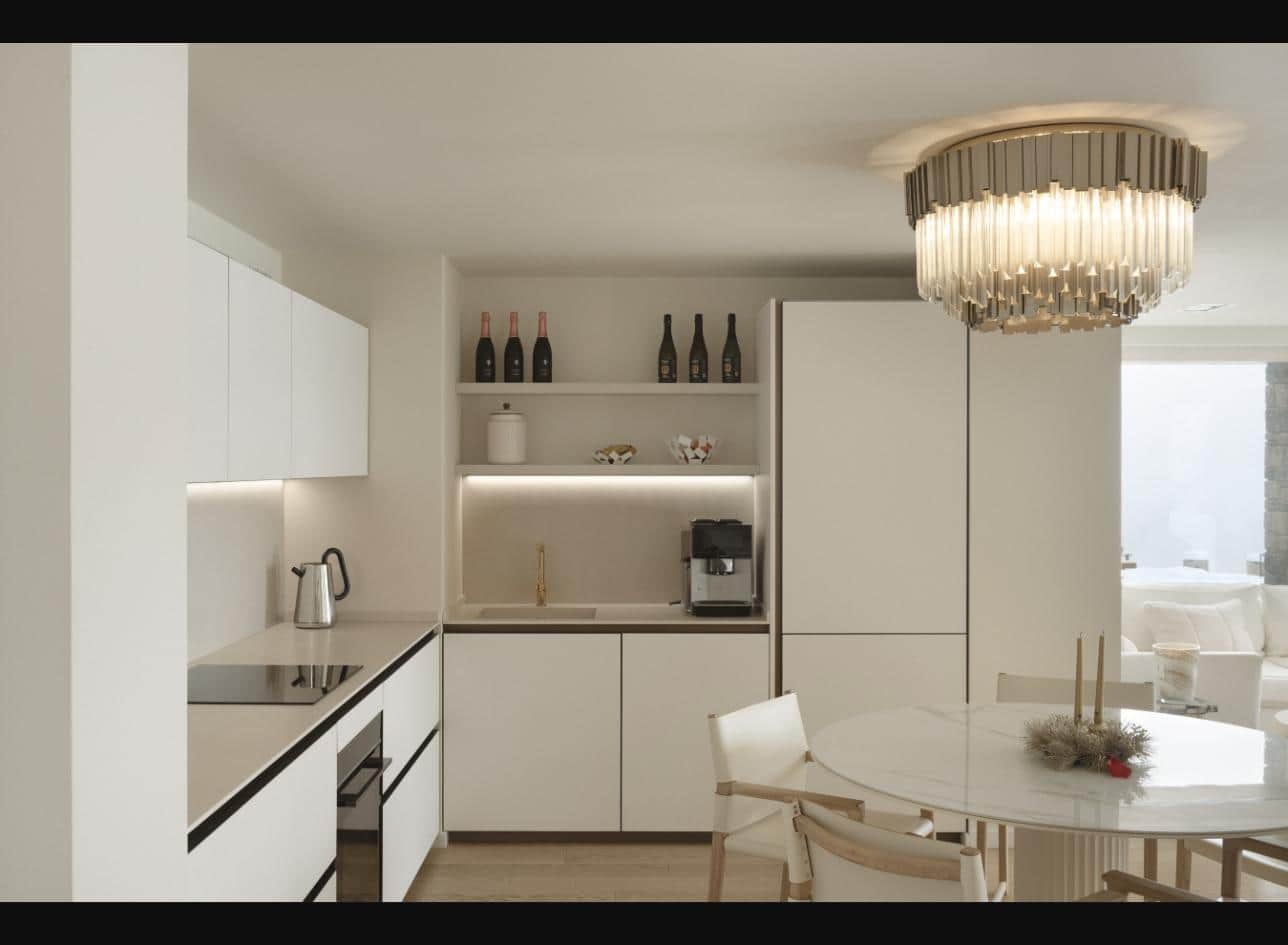 Fully equipped kitchen with dining table under a crystal chandelier
