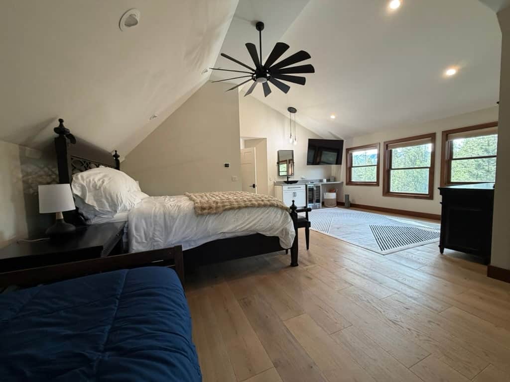 Vaulted-ceiling primary bedroom with king bed with mountain views and twin daybed/trundle bed