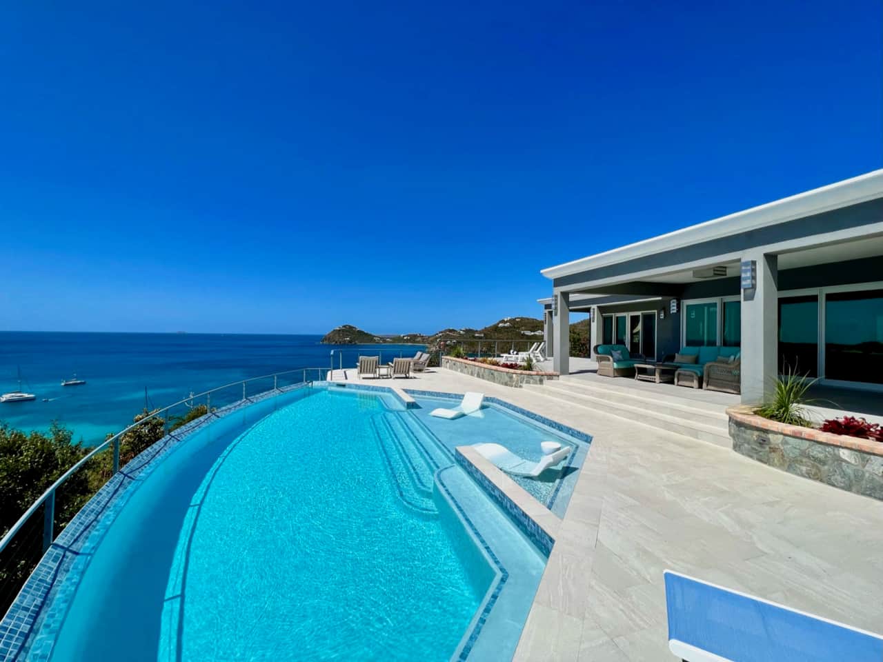 Big infinity pool with a patio that wraps around it