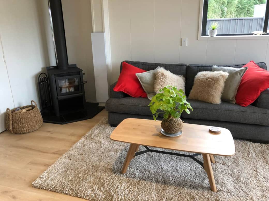 Cosy lounge with fireplace and heatpump. The smart tv is wall mounted, opposite the couch