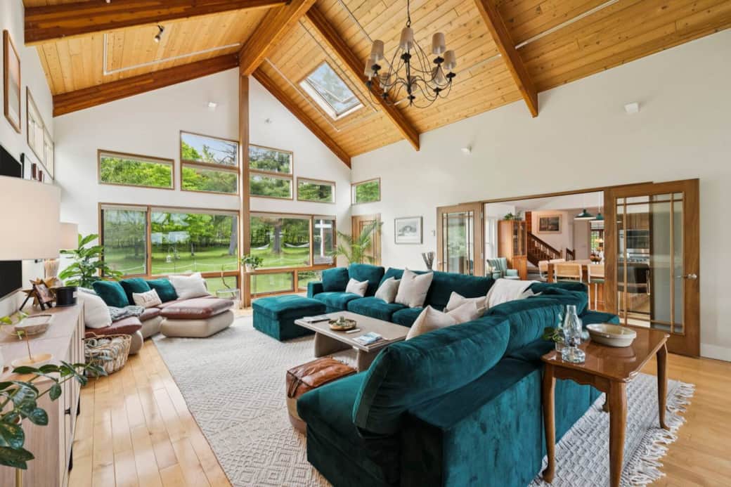 Just beyond, double glass doors lead to a cozy coffee nook and chef’s kitchen while sliding glass doors lead to the screened-in porch with outdoor dining table and living room, allowing for seamless indoor/outdoor entertaining.