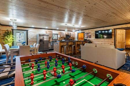 Open living area with games, dining and bar seating next to the kitchen