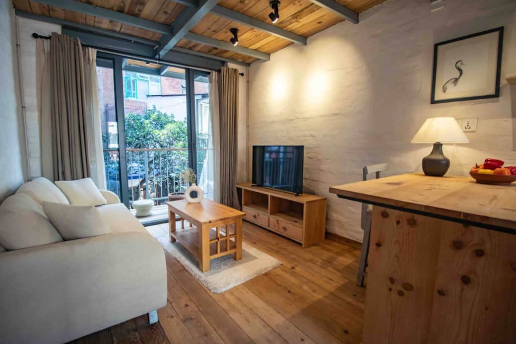 Living room with sofa and TV and open kitchennette