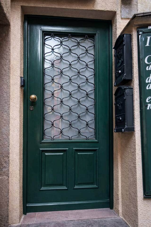 Ingresso indipendente con porta in legno verde e vetro decorato, che dona carattere e privacy. Accesso comodo e riservato, situato in un contesto tranquillo e curato.