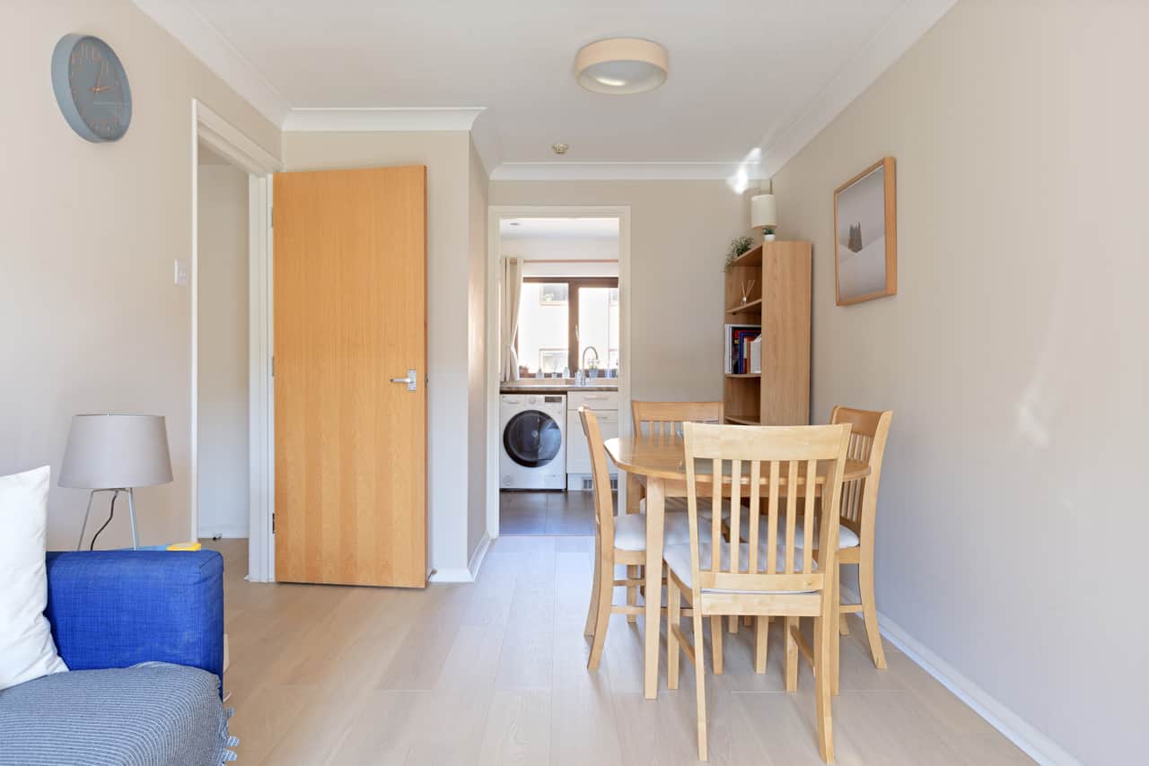 Hallway with wall clock leading through to the kitchen