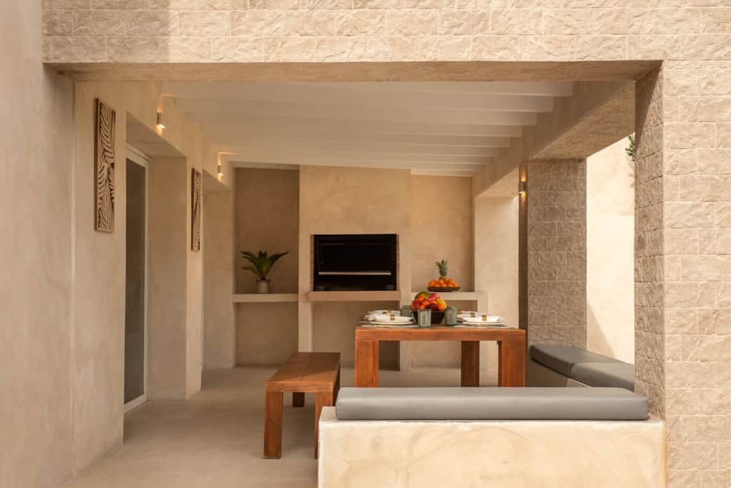 Covered terrace with large dining table for up to 12 guests with BBQ and direct access to the pool area