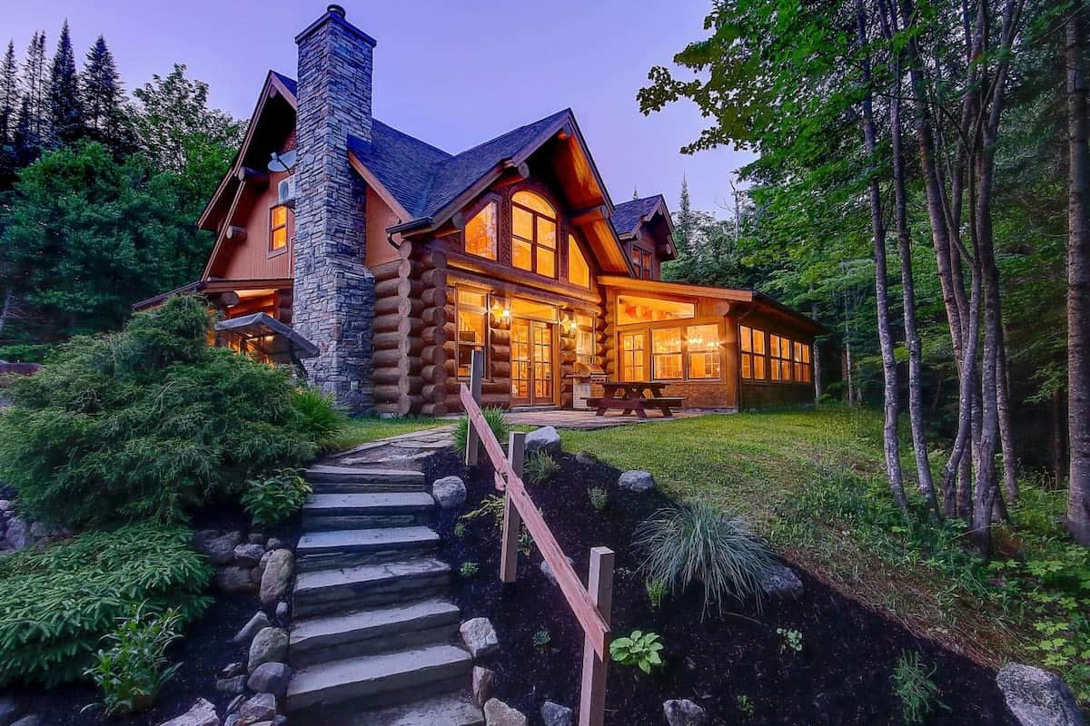 Log chalet glowing at dusk, surrounded by forest