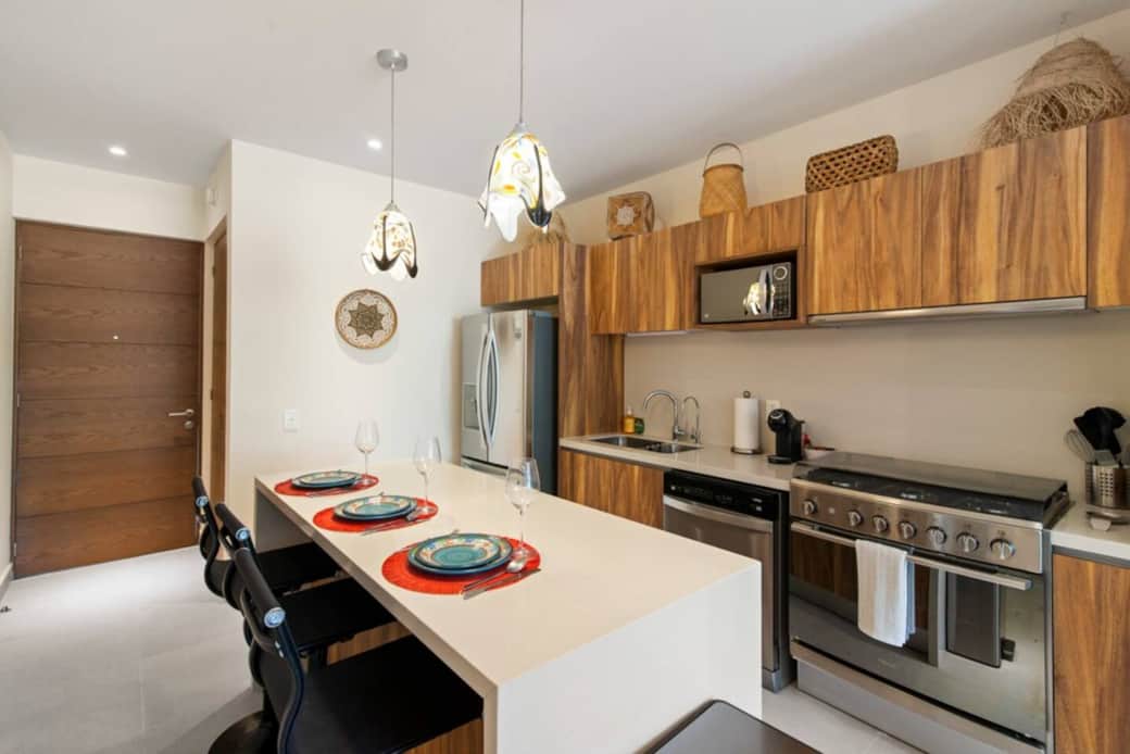Fully equipped kitchen with coffee machine, cookware, and island seating.