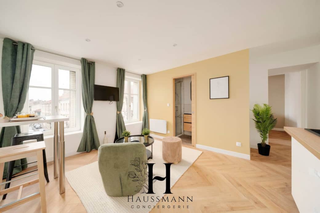 ️ Salon lumineux avec grandes fenêtres, TV 4K murale et Wi-Fi haut débit. Décoration élégante, mobilier confortable et coin repas convivial avec vue sur la Place Duroc. Un espace idéal pour se détendre ou partager un moment chaleureux.