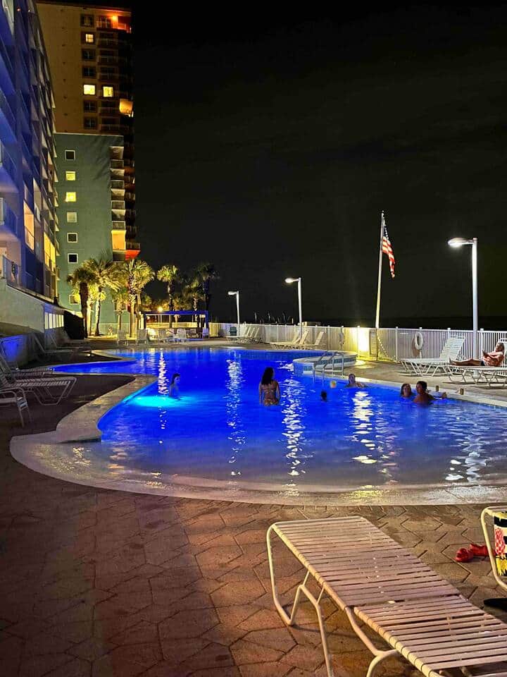 Pool being enjoyed by teens at night