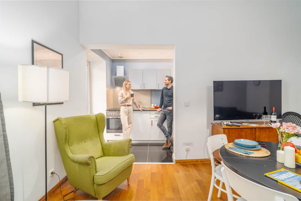 Jasne, otwarte wnętrze łączące salon z kuchnią.