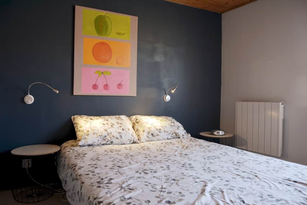 Chambre Fromentine, lit double, décoration, intérieur, confortable, location vacances Fromentine, hébergement Vendée, nuit, repos, mur bleu, ambiance cosy.