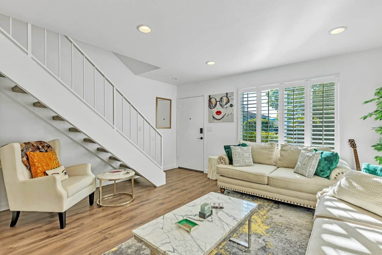 Relax in this stylish living room filled with natural light. A soft sofa, large TV, and airy ambiance create a welcoming space to unwind after a day of adventure.