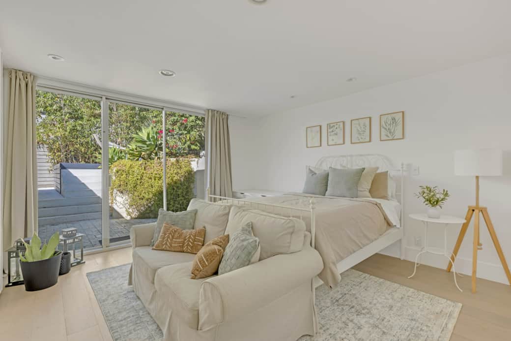 Queen bedroom with plush seating facing a neatly made bed and textured pillows. Queen bedroom with plush seating facing a neatly made bed and textured pillows.