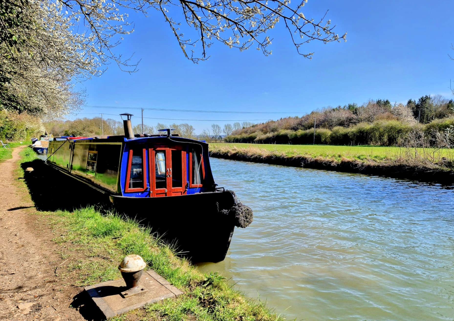 Holiday canal boat moored on a countryside towpath