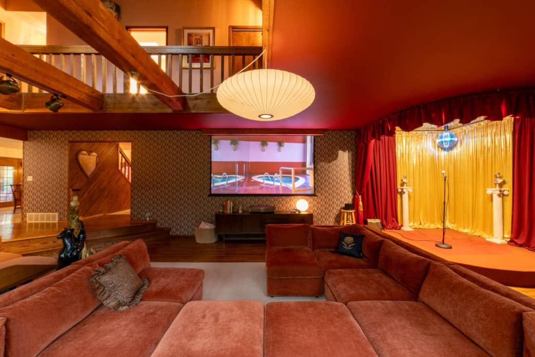 Expansive living room with a built-in stage, disco ball, and a 120” 4K home theater for movie nights Expansive living room with a built-in stage, disco ball, and a 120” 4K home theater for movie nights