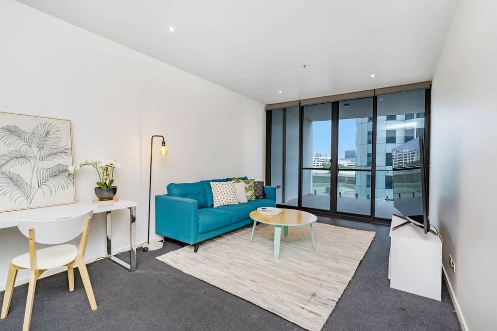 Immerse yourself in the vibrant energy of our living space. The striking blue sofa and the warm hues of the rug create an inviting atmosphere. With a large window that frames the cityscape, this is the perfect spot to relax .