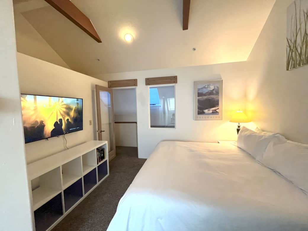 Primary bedroom with king bed, flatscreen TV and en suite bathroom