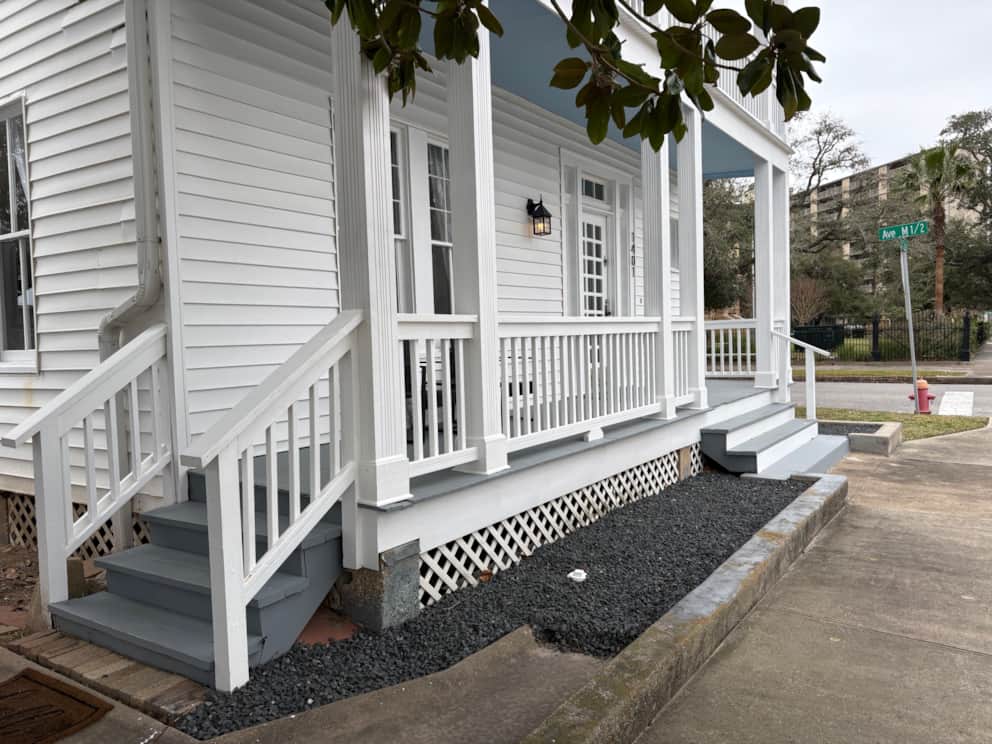 Front porch seating at White Magnolia Galveston with shaded historic charm