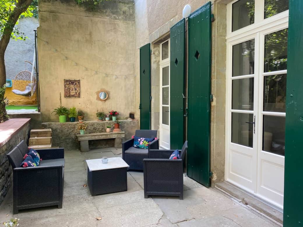 Cozy outdoor seating area with stylish furniture and greenery in a tranquil Carcassonne courtyard Cozy outdoor seating area with stylish furniture and greenery in a tranquil Carcassonne courtyard