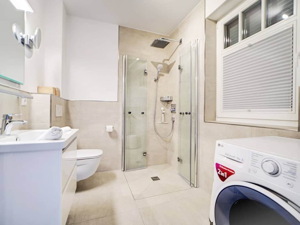 Auri Bad im Erdgeschoss mit Dusche waschbecken Toilette und Waschtrockner