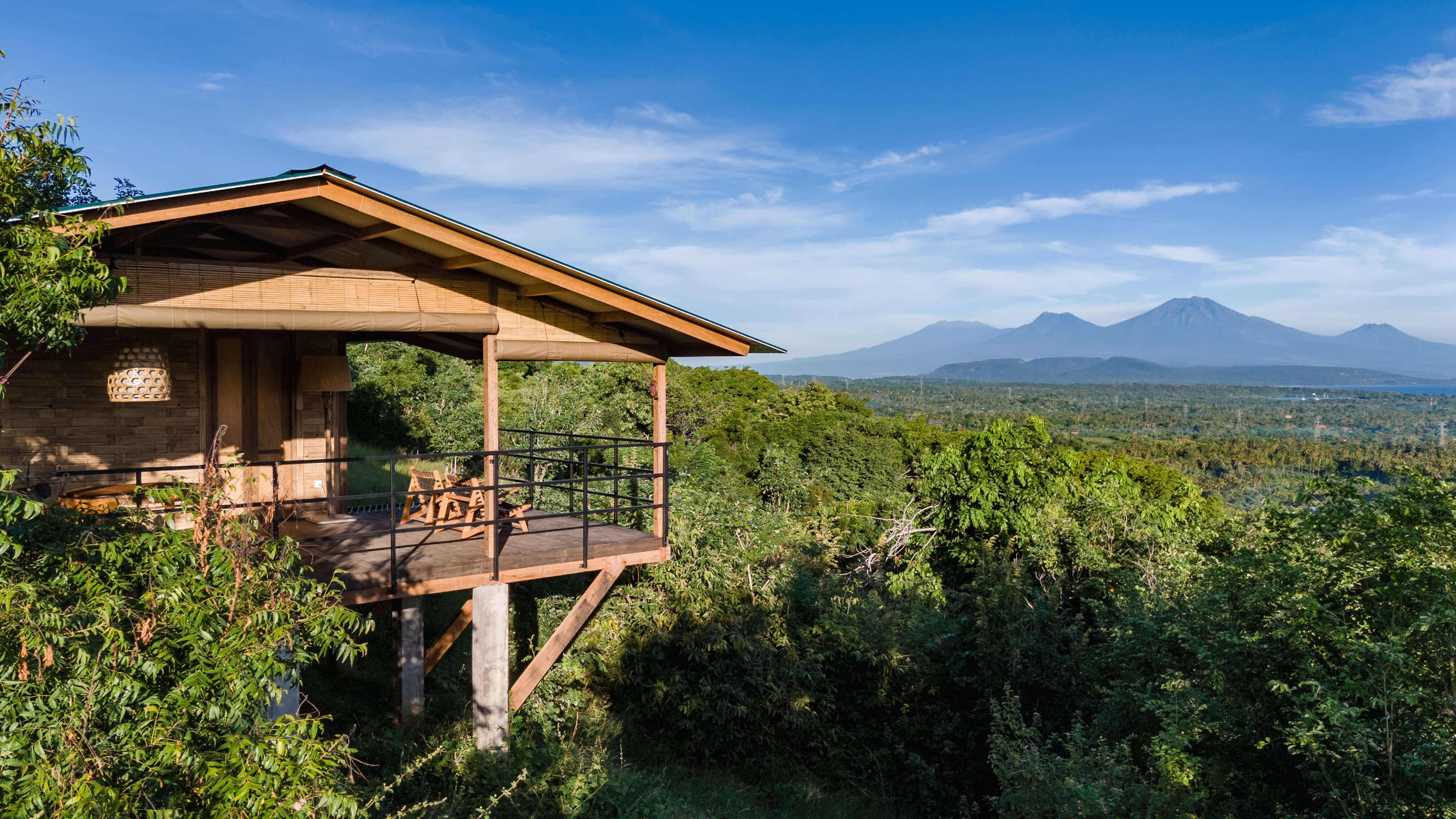 Comfort Cabin 7 elevated exterior view showing traditional Indonesian architecture on stilts with dramatic mountain backdrop
