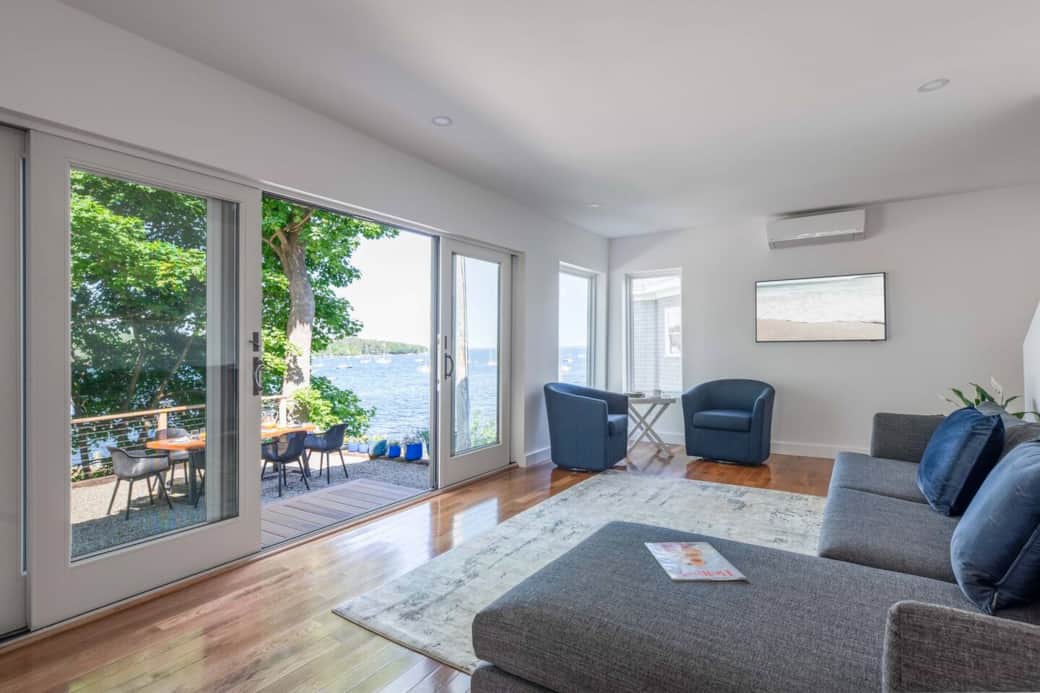 The living room is positioned towards the outdoor patio and the doors open wide enough for a true indoor/outdoor experience. There is also a television and heat pump in this space. 