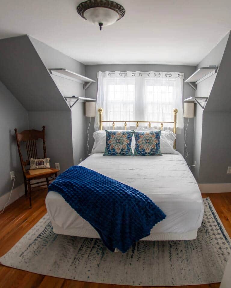 An upstairs bedroom with a comfortable full bed, this room boasts a tv, hanging shelves and charging stations for your cell phones and such, dresser walk-in closet and mirror.