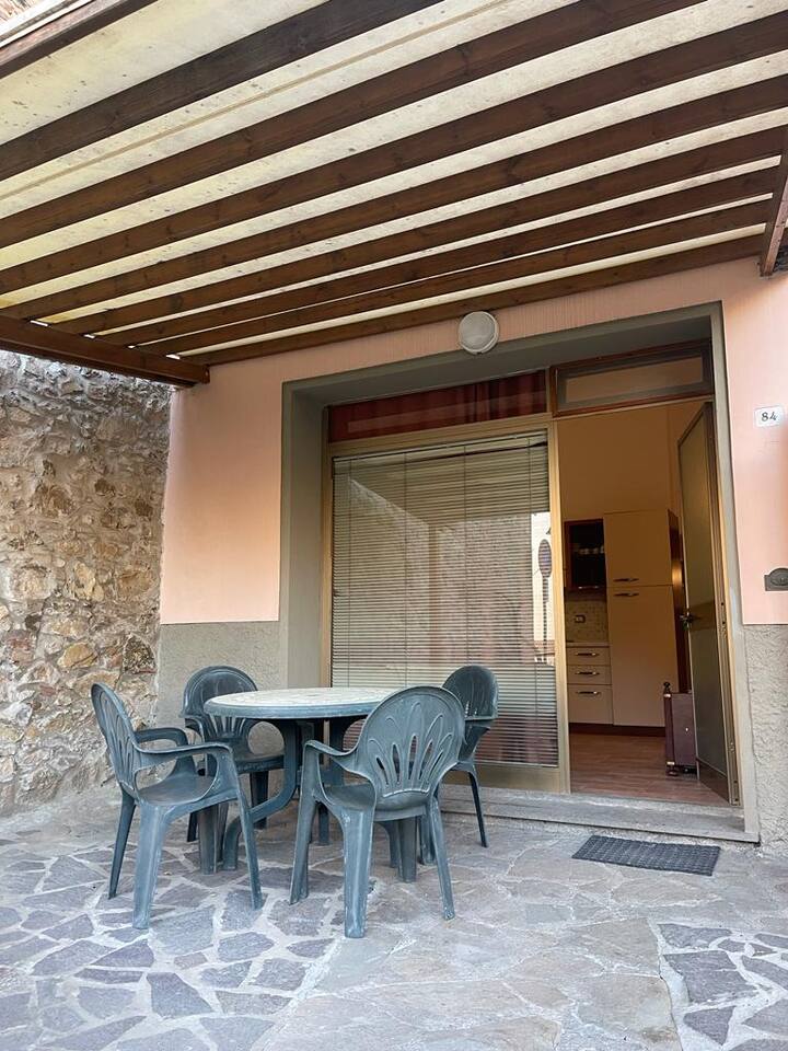 Patio esterno fronte strada con tavolo e sedie 