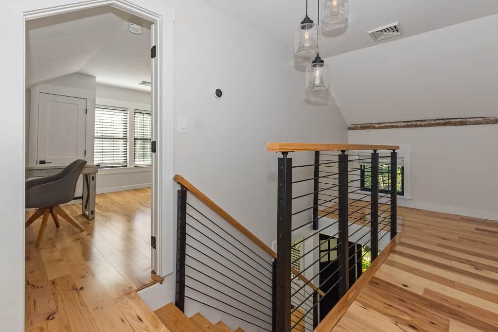 Upstairs landing with modern railing leading to bright home office Upstairs landing with modern railing leading to bright home office