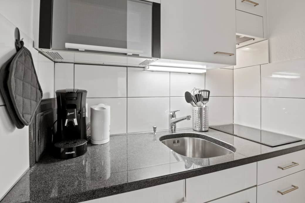 Kitchen unit with coffee machine, kettle and basic cooking equipment.